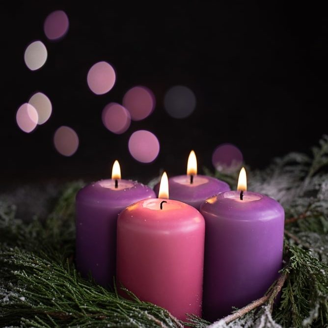 Three,Purple,And,One,Pink,Advent,Candles,And,Snow Covered,Spruce